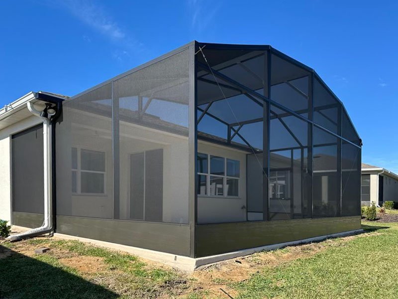 High roof lanai enclosure installation in Davie, FL showing black aluminum frame with upgraded mesh