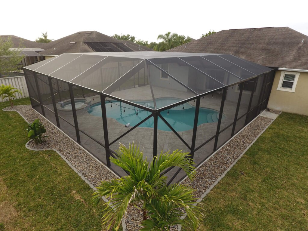 Completed pool enclosure installation in Davie, FL surrounding residential backyard swimming pool