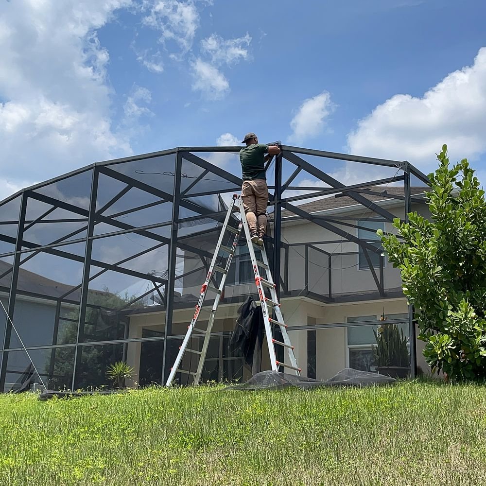 Technician performing pool screen repair in Davie, FL using ladder on enclosure frame